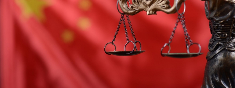 image of scales of justice with Chinese flag at the background