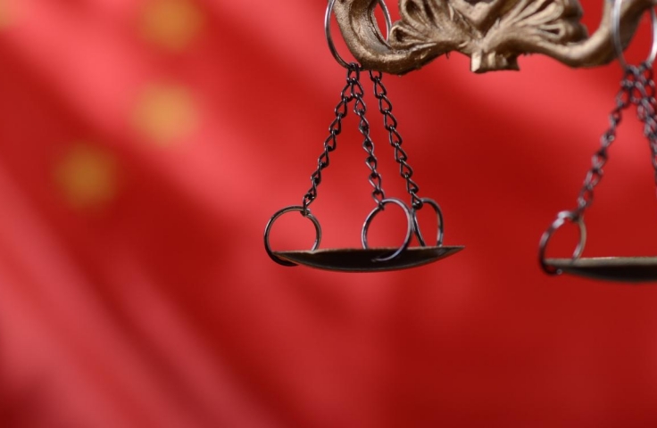 image of scales of justice with Chinese flag at the background