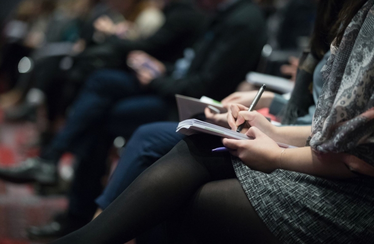 Group of people at conference taking notes 